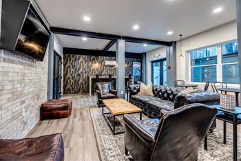 A modern living room with a leather couch and a wooden coffee table.
